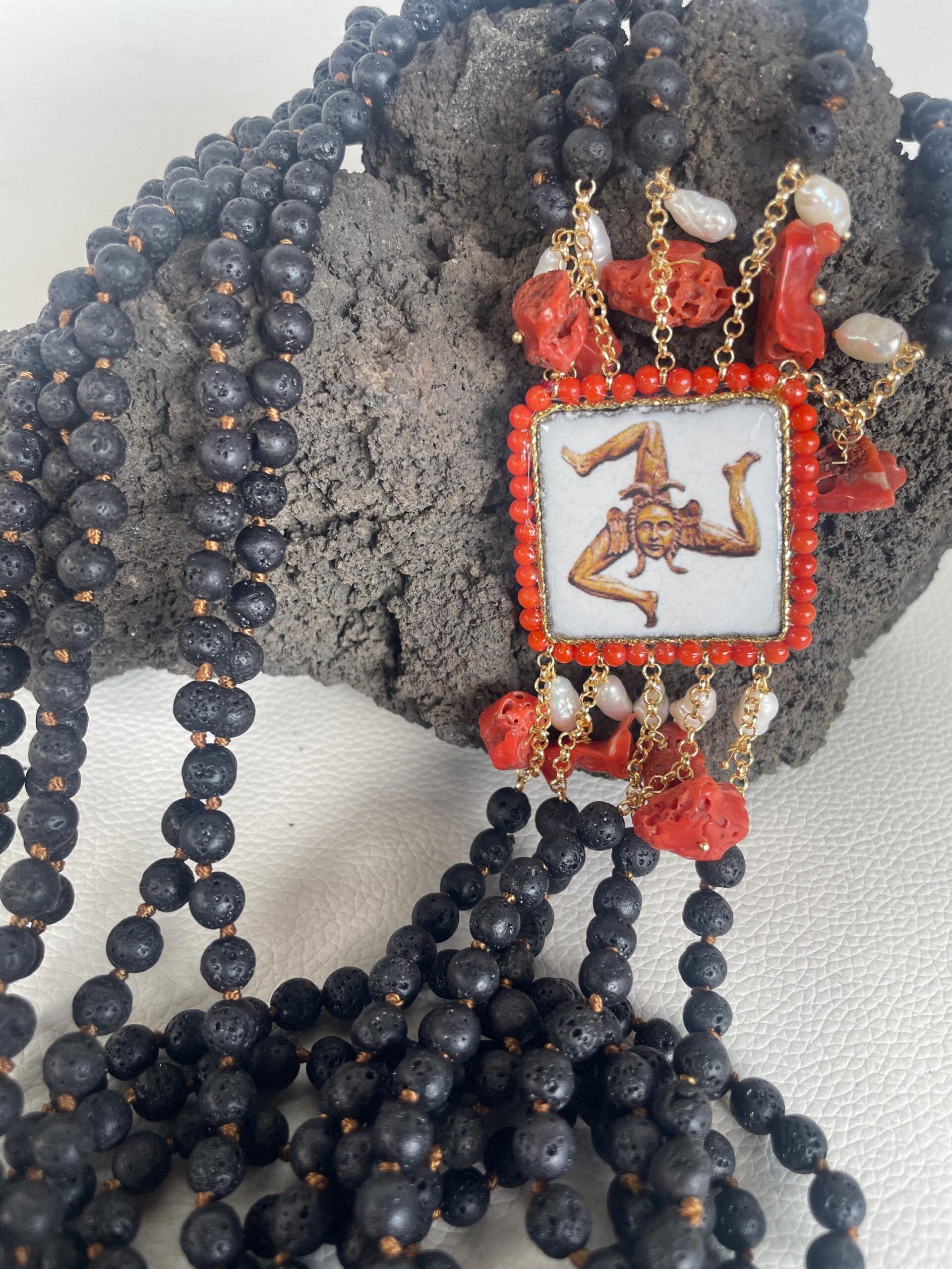 Collana siciliana multifilo, 5 fili di pietra lavica, collana annodata a mano, mattonella Caltagirone raffigurante Trinacria. Collane con Mattonelle Caltagirone