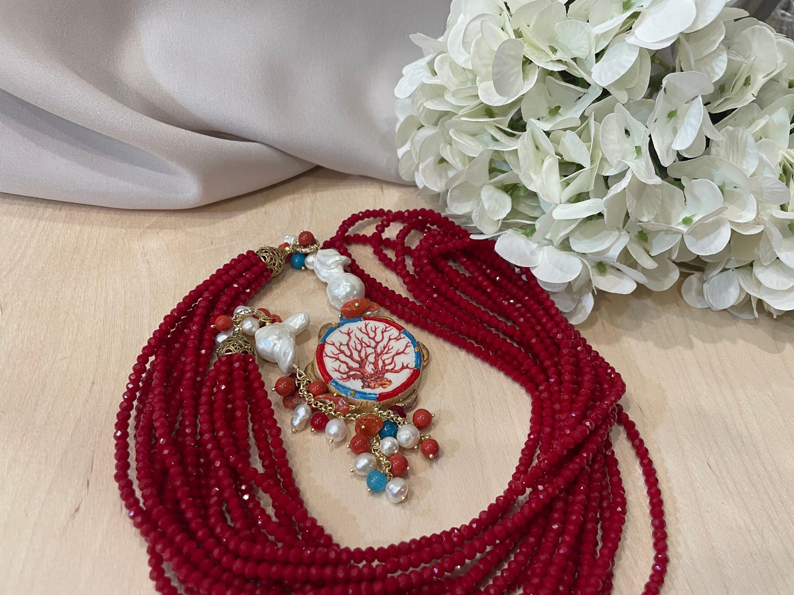 Collana multifilo con cristalli,  collana lunga con tamburello di ceramica di Caltagirone, perle scaramazze e pietre dure. Collane caratteristiche siciliane