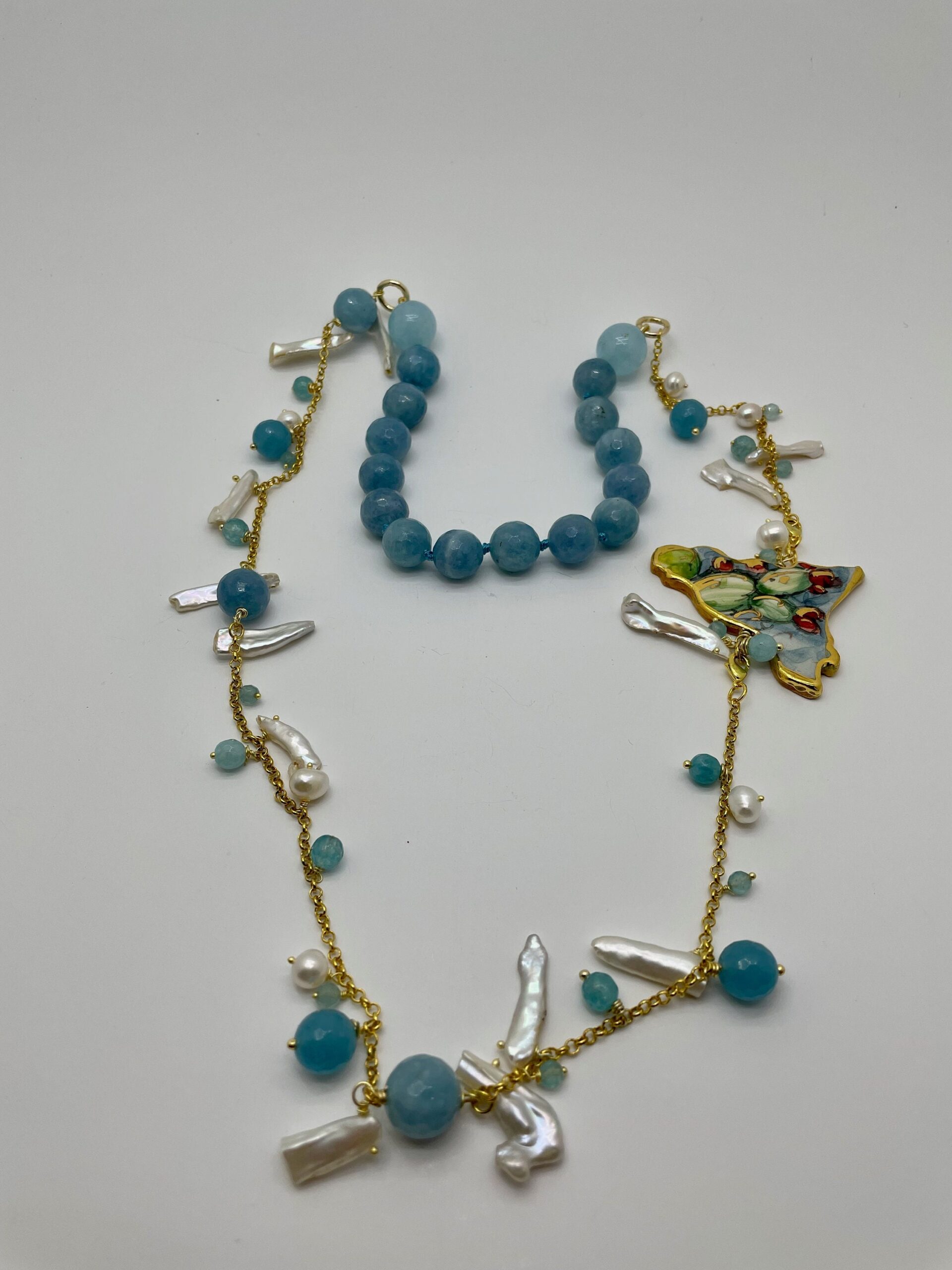 Collana pietre dure, angelite, sagoma Sicilia in ceramica di Caltagirone,  perle scaramazze, catena placcata oro. regalo per lei. Collane caratteristiche siciliane