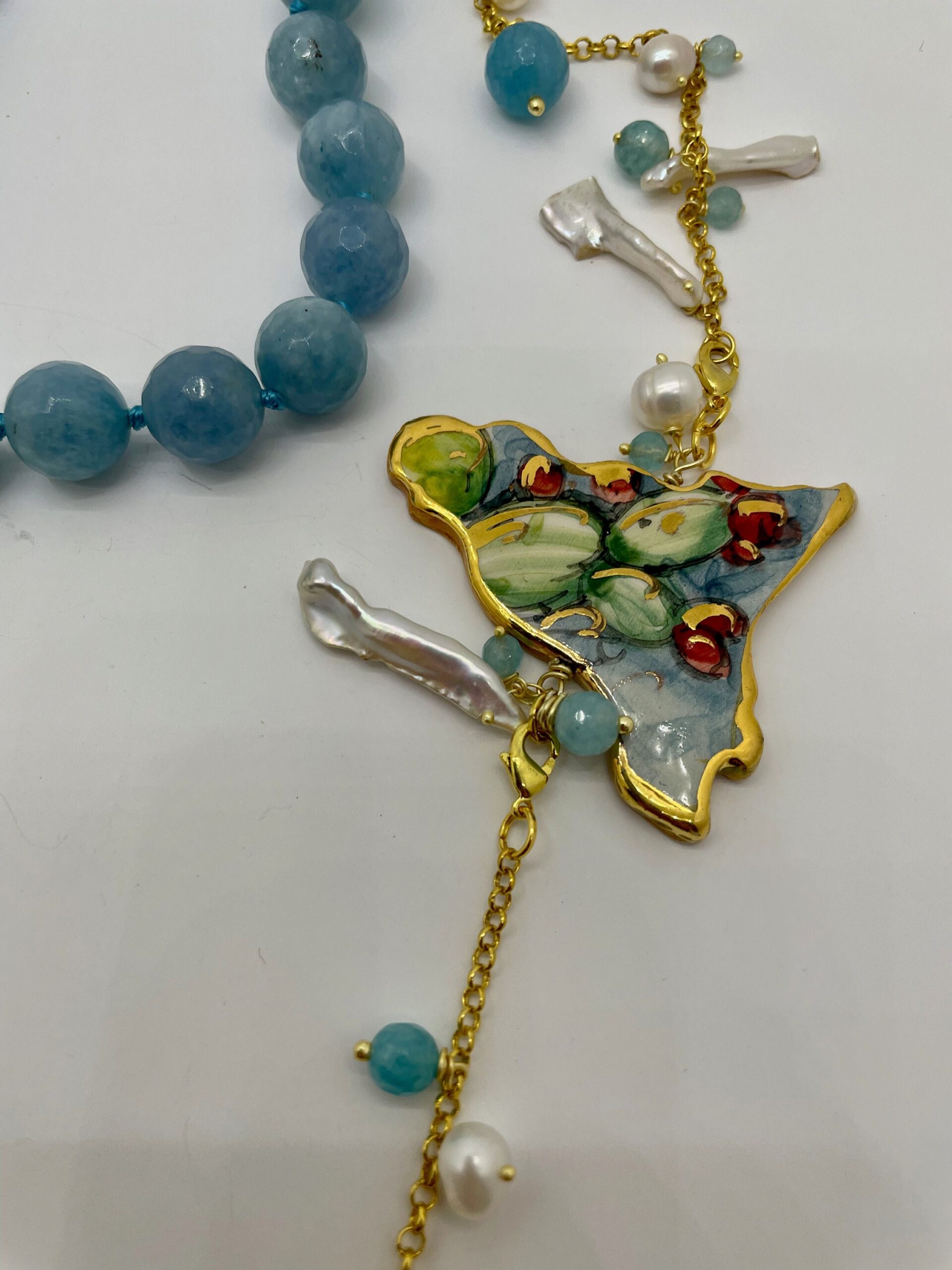 Collana pietre dure, angelite, sagoma Sicilia in ceramica di Caltagirone,  perle scaramazze, catena placcata oro. regalo per lei. Collane caratteristiche siciliane