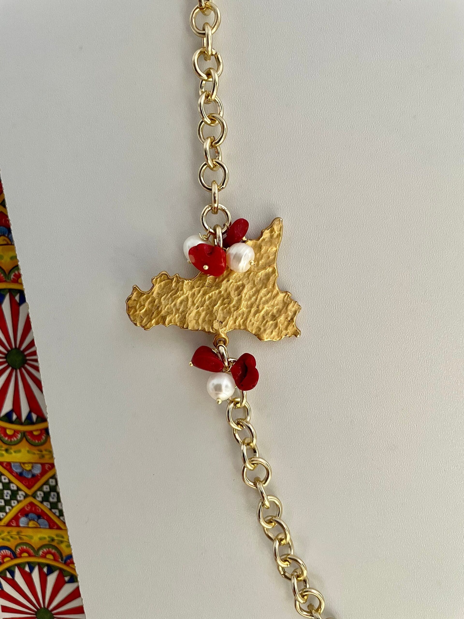 Collana con ciondolo sicilia in ottone, catena alluminio, perle di fiume e chips di corallo. Collane caratteristiche siciliane