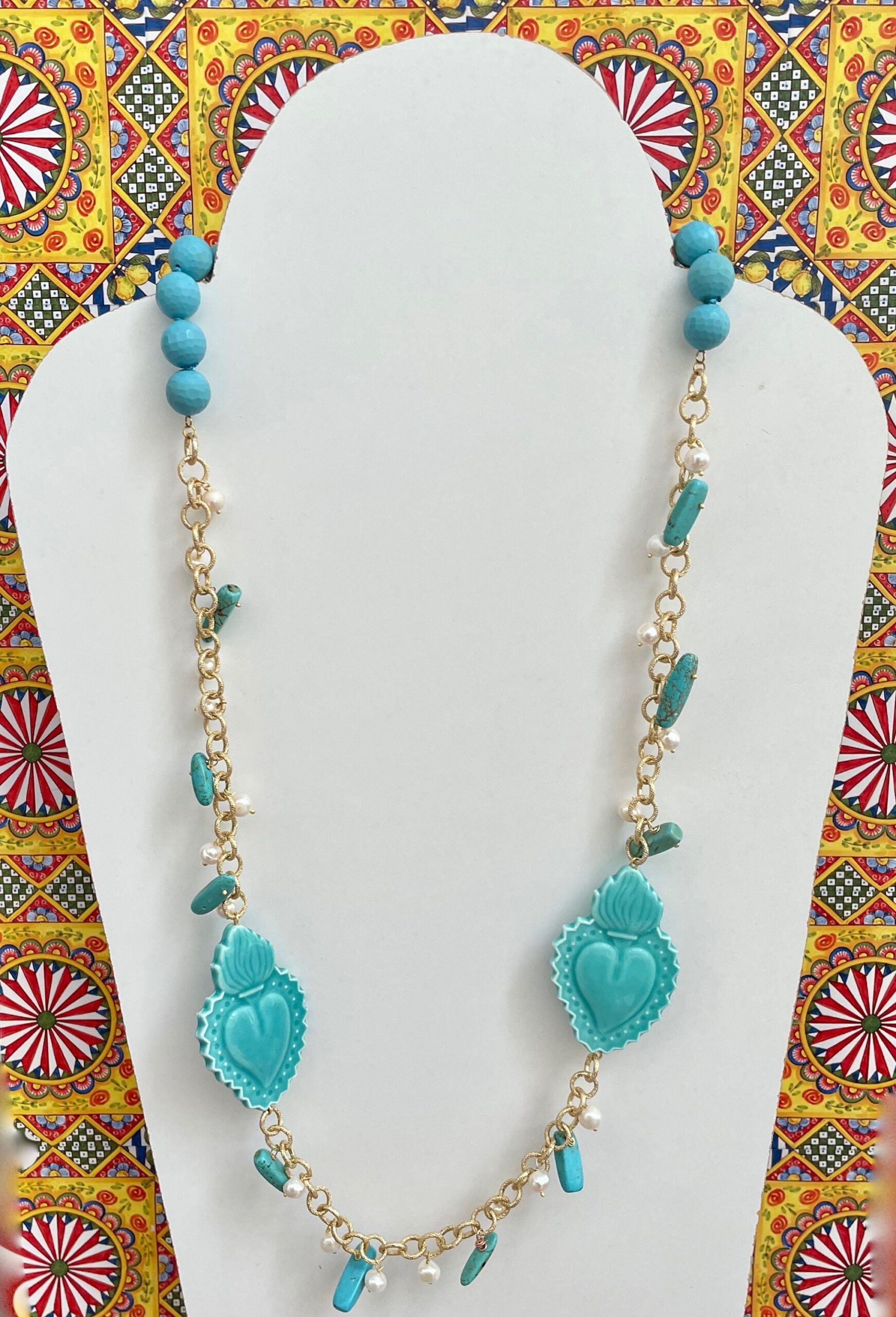 Collana lunga turchese, cuori sacri in ceramica di Caltagirone, perle di fiume, pasta di turchese, chips turchesi, catena alluminio dorata. Collane caratteristiche siciliane