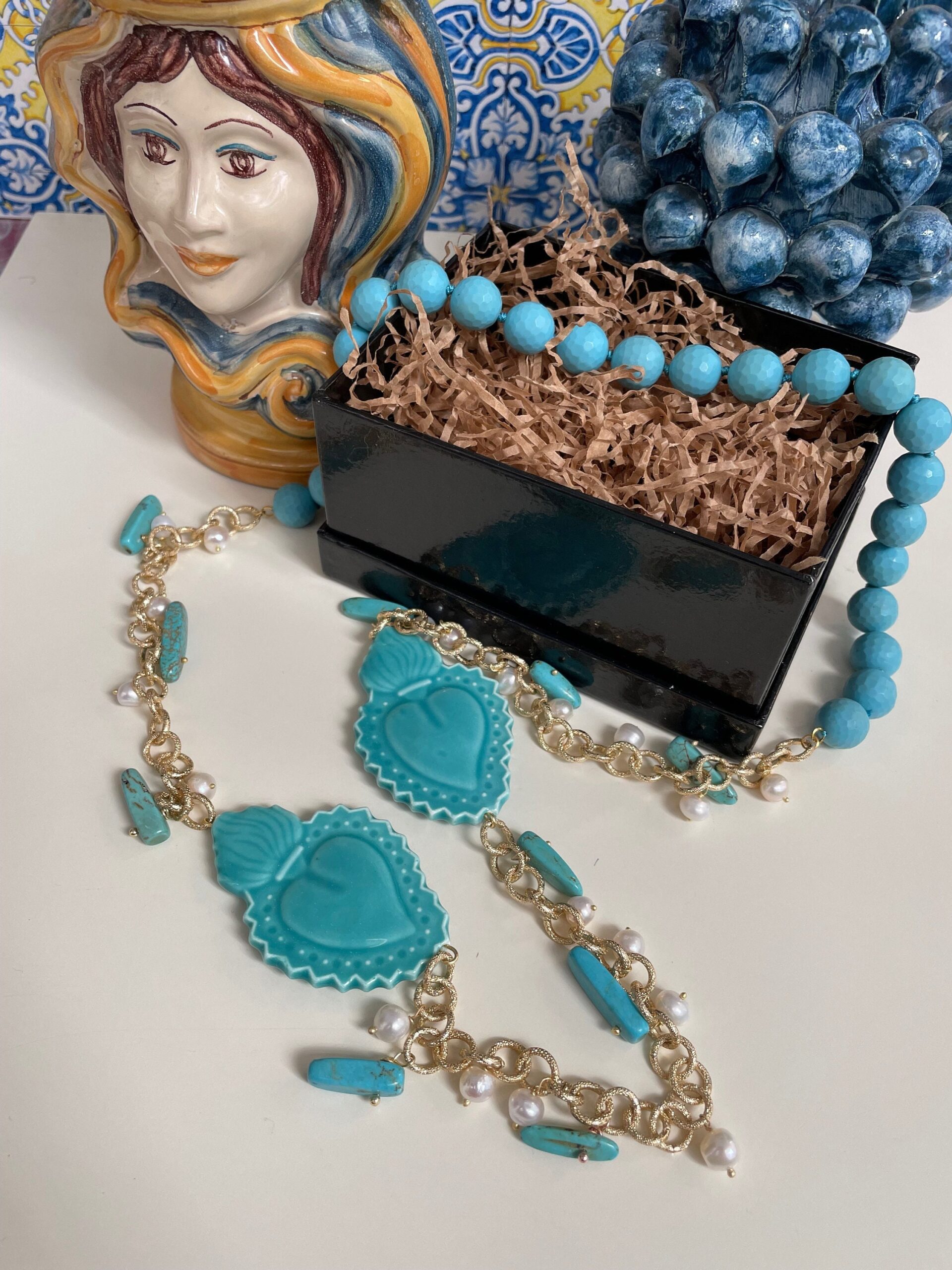 Collana lunga turchese, cuori sacri in ceramica di Caltagirone, perle di fiume, pasta di turchese, chips turchesi, catena alluminio dorata. Collane caratteristiche siciliane