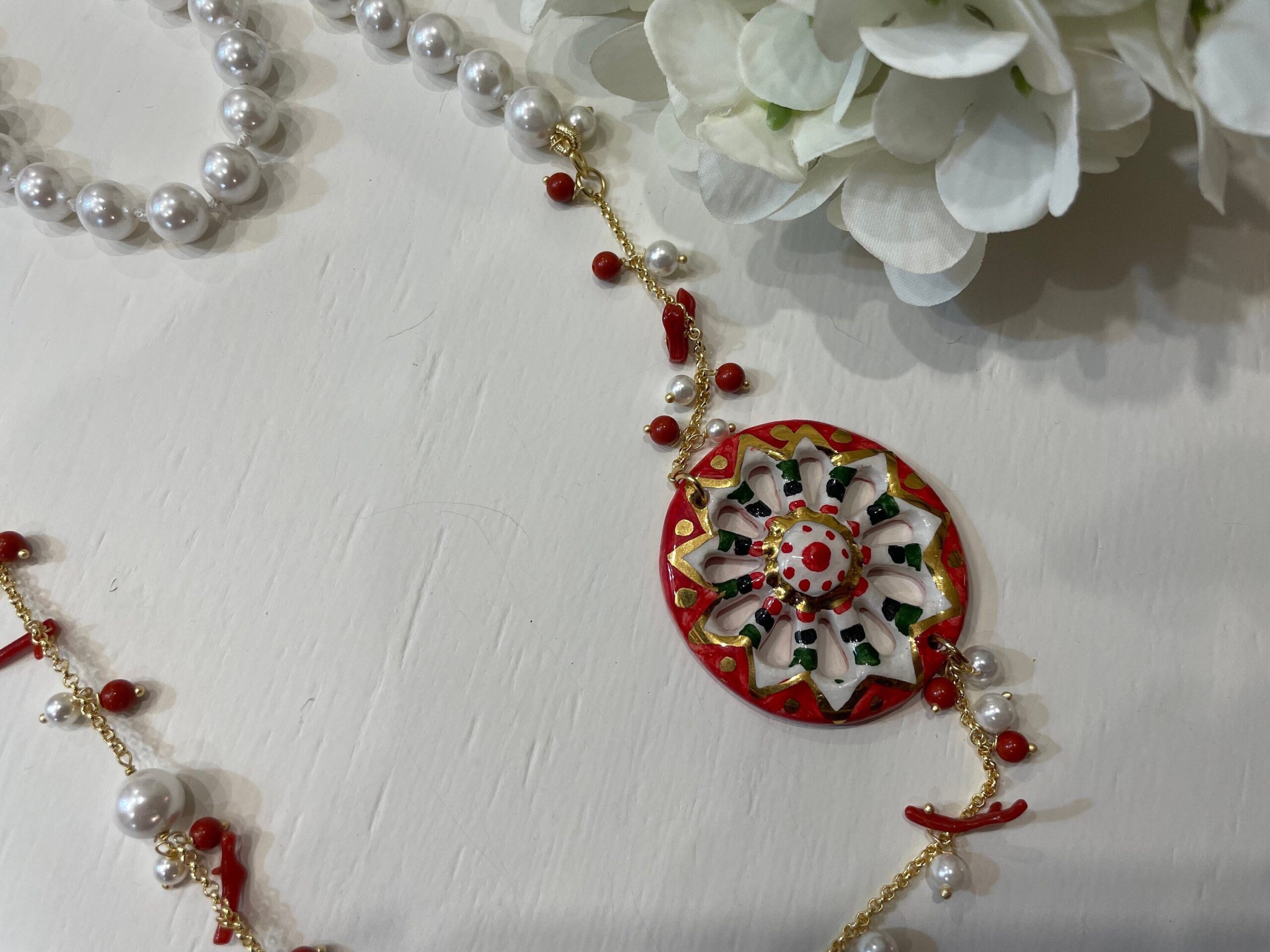 Collana siciliana con ruota di carretto in ceramica di caltagirone, perle maiorca bianche e corallo. regalo per lei. Collane caratteristiche siciliane