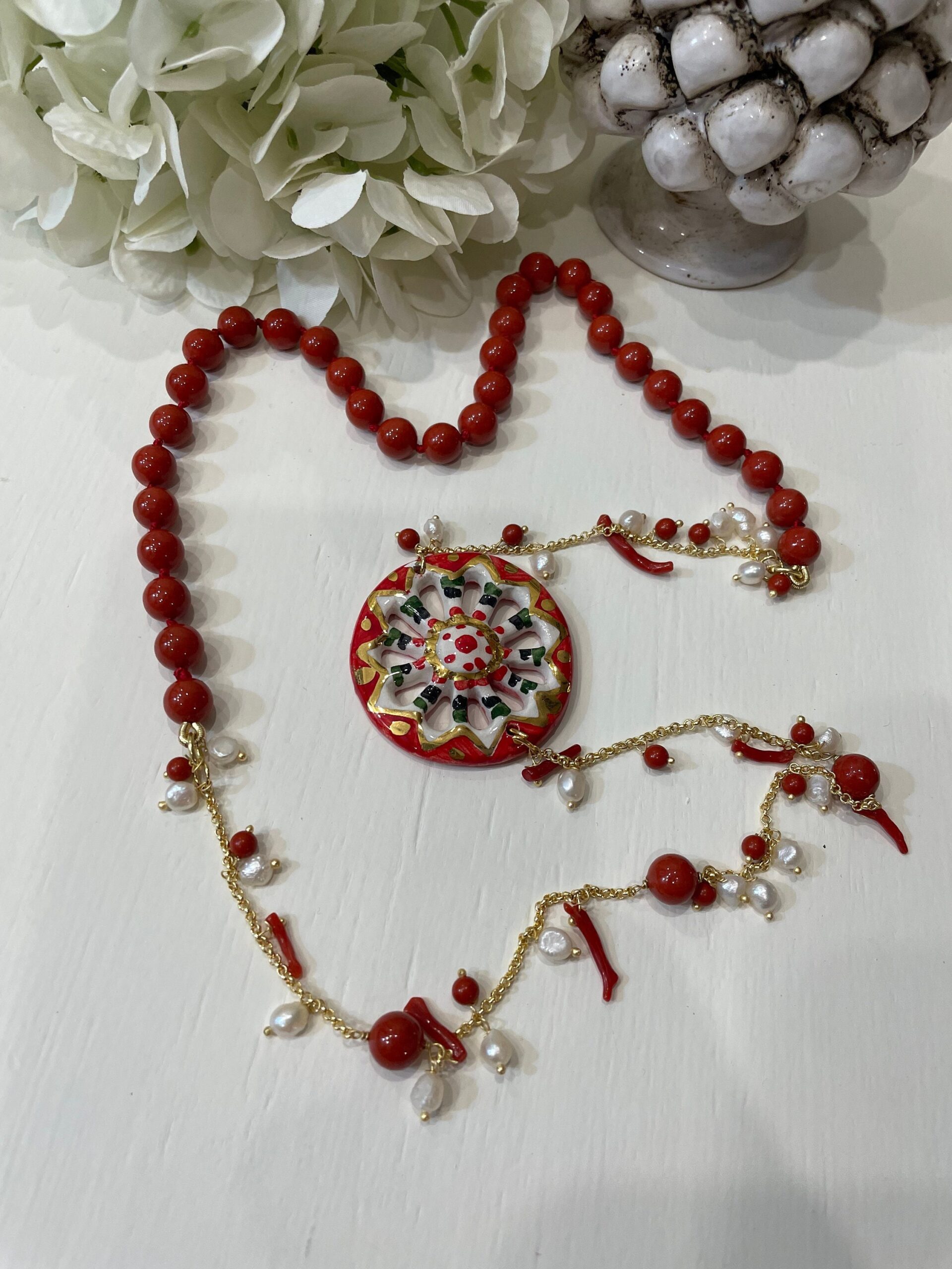 Collana siciliana con ruota di carretto in ceramica di Caltagirone, perle maiorca rosse e corallo. regalo per lei. Collane caratteristiche siciliane