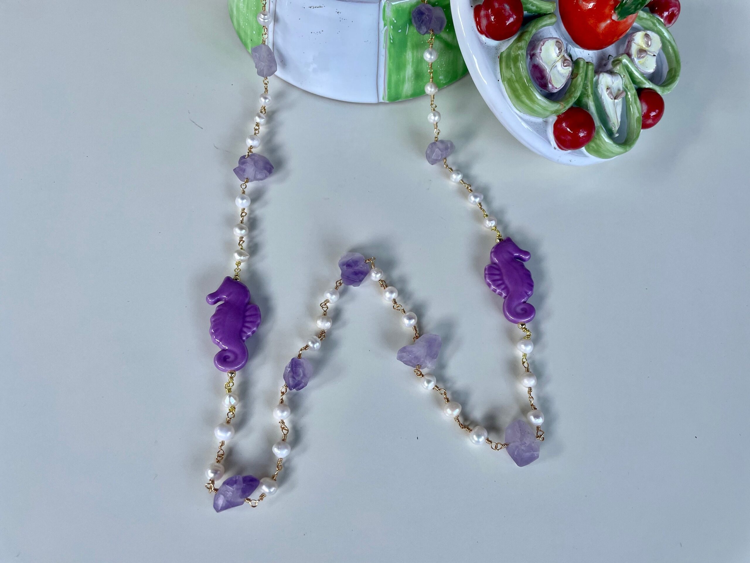 Collana siciliana, lunga, sassi di ametista, perle di fiume e cavallucci marini in ceramica di Caltagirone. Collane caratteristiche siciliane