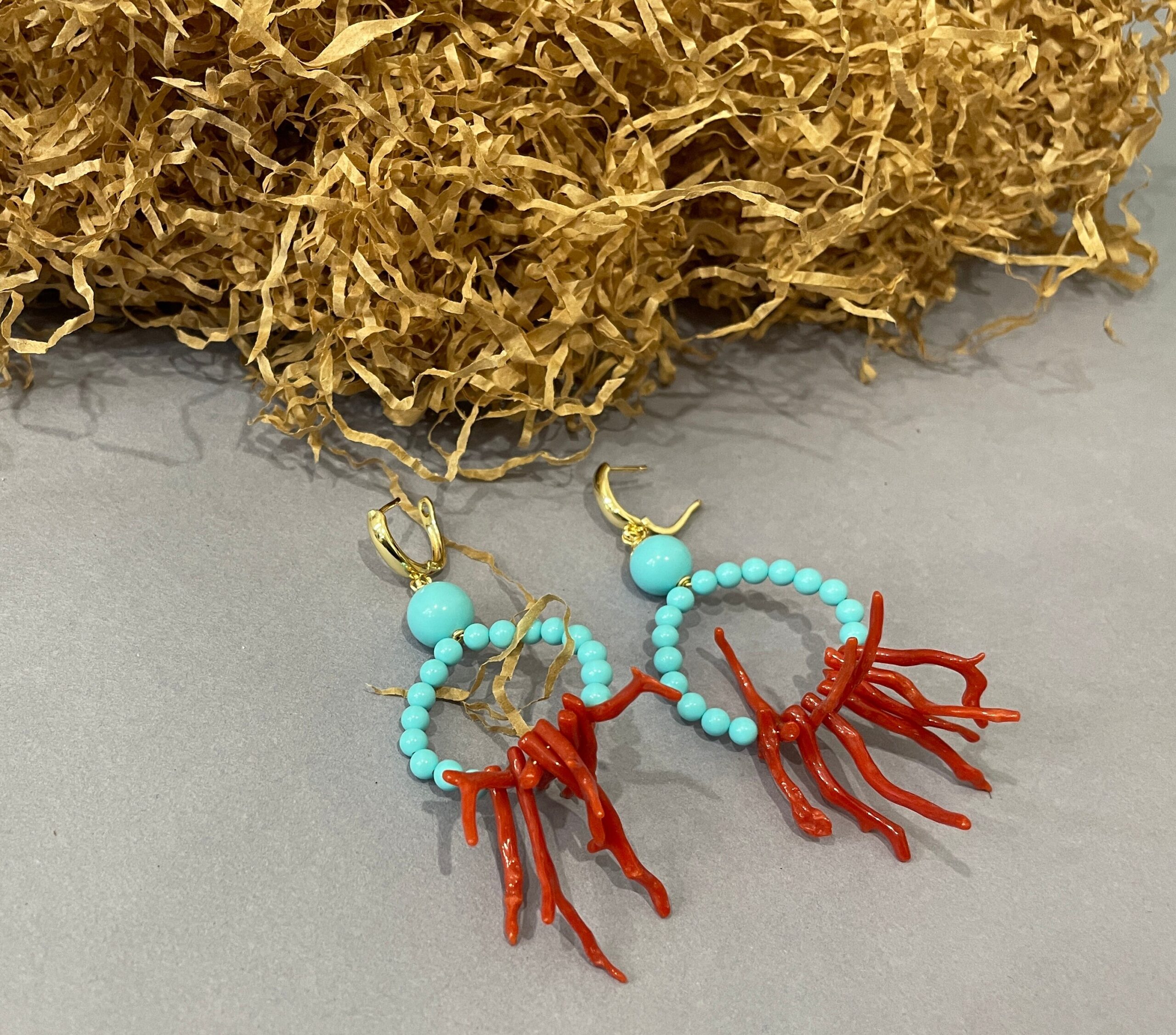 Orecchini da lobo, gancio chiuso in ottone placcato oro, pendente un anello di perle turchesi e rami di Corallo autentico del Mediterraneo. Corallo del Mediterraneo
