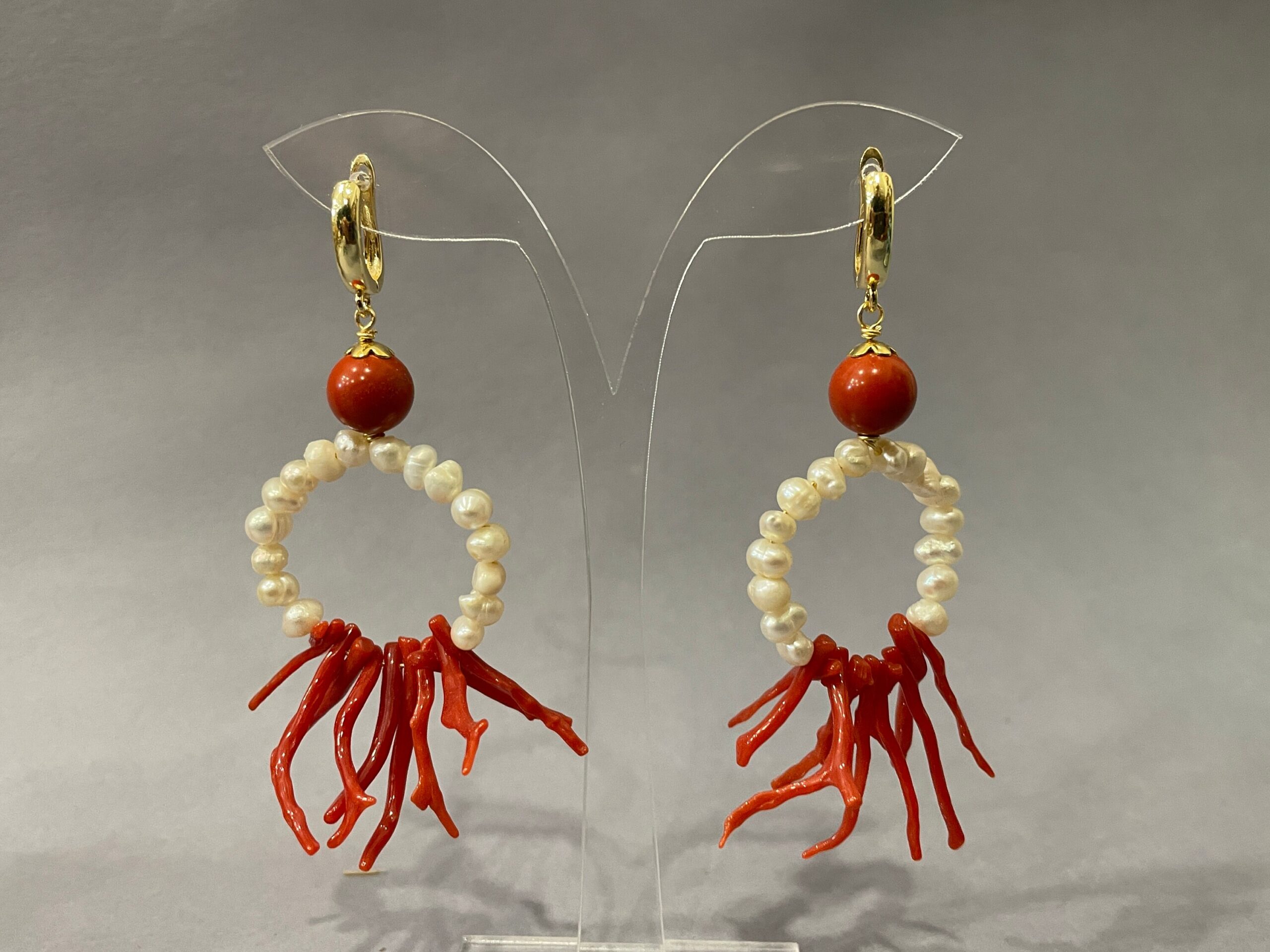 Orecchini da lobo, gancio chiuso in ottone placcato oro, pendente un anello di perle naturali e rami di Corallo autentico del Mediterraneo. Corallo del Mediterraneo