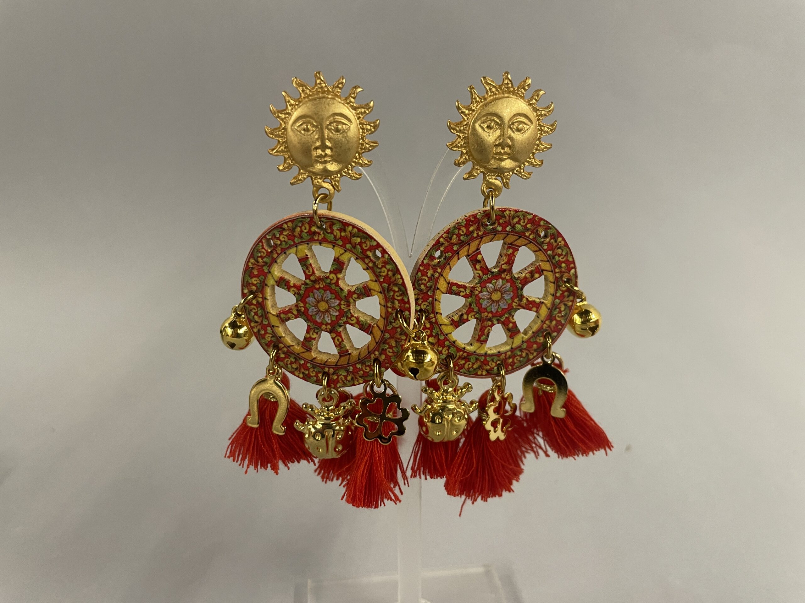 orecchini artigianato siciliano con ruota di carretto e nappe rosse