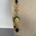 Collana siciliana con perle di lava annodate a mano, limone ceramica di Caltagirone, grappoli di perle di lava e Agata gialla. Collane caratteristiche siciliane