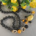 Collana siciliana con perle di lava annodate a mano, limone ceramica di Caltagirone, grappoli di perle di lava e Agata gialla. Collane caratteristiche siciliane