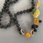 Collana siciliana con perle di lava annodate a mano, limone ceramica di Caltagirone, grappoli di perle di lava e Agata gialla. Collane caratteristiche siciliane