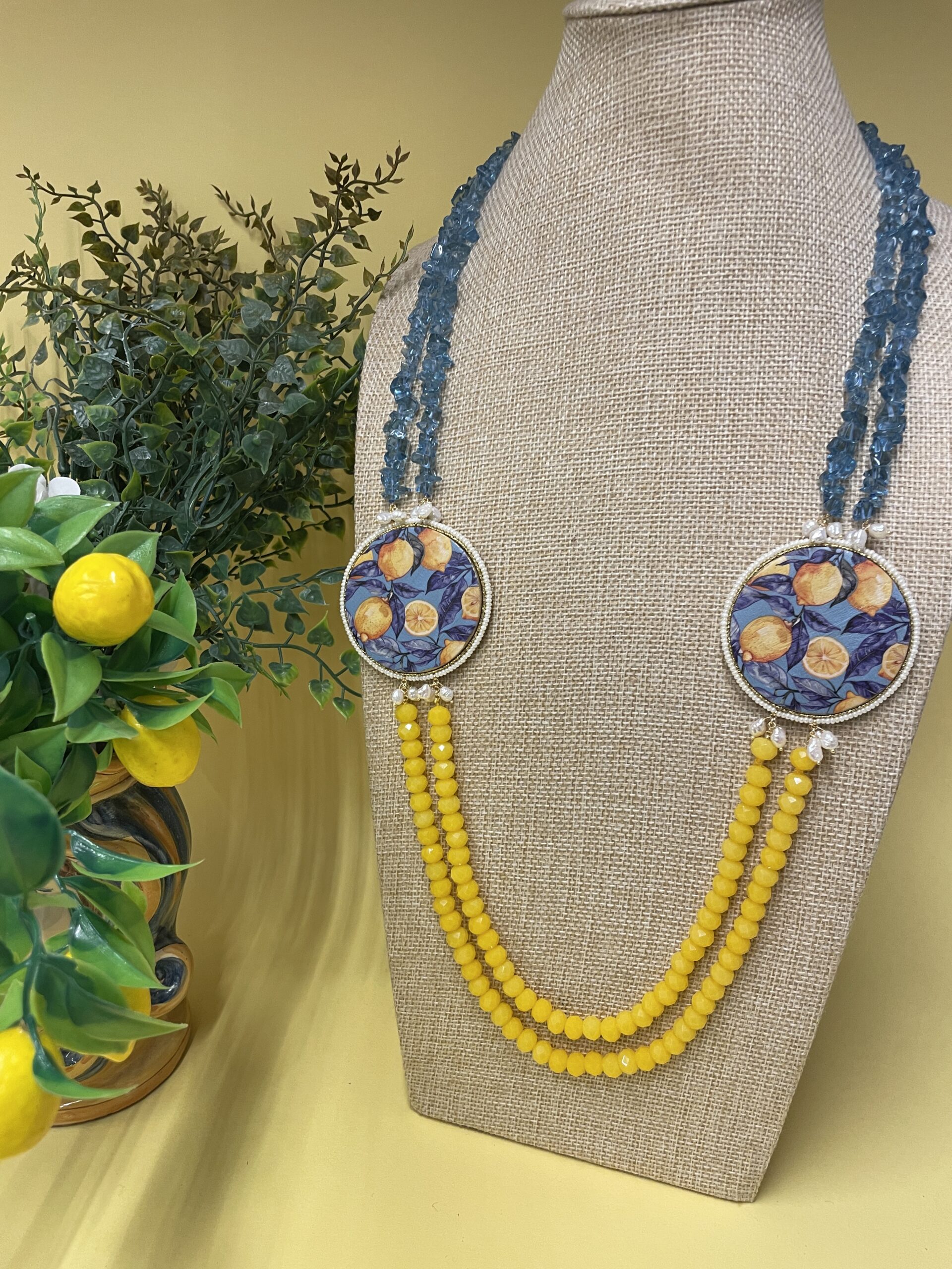 Collana artigianale con medaglioni double-face raffiguranti Limoni e fantasie geometriche, doppio colore giallo e acquamarina. Collane caratteristiche siciliane