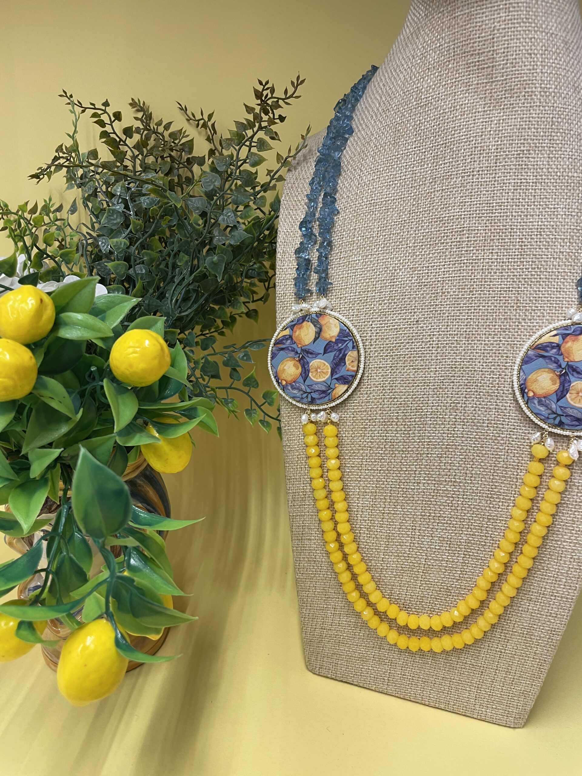 Collana artigianale con medaglioni double-face raffiguranti Limoni e fantasie geometriche, doppio colore giallo e acquamarina. Collane caratteristiche siciliane