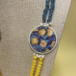 Collana artigianale con medaglioni double-face raffiguranti Limoni e fantasie geometriche, doppio colore giallo e acquamarina. Collane caratteristiche siciliane