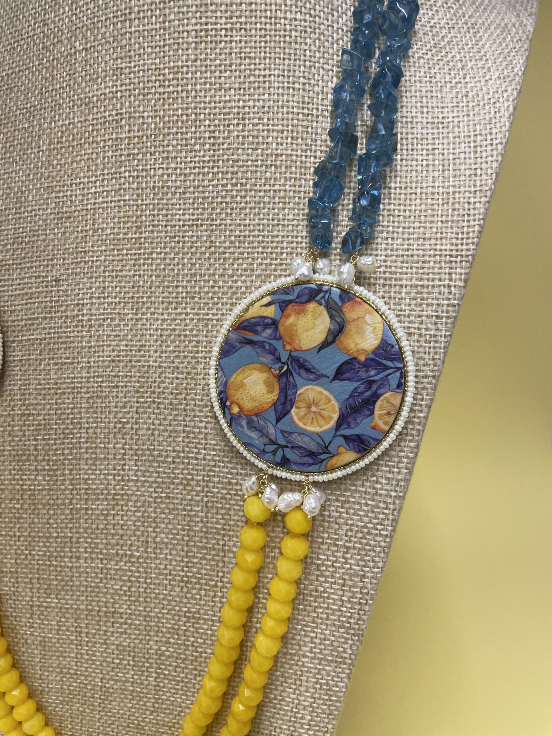 Collana artigianale con medaglioni double-face raffiguranti Limoni e fantasie geometriche, doppio colore giallo e acquamarina. Collane caratteristiche siciliane