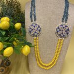 Collana artigianale con medaglioni double-face raffiguranti Limoni e fantasie geometriche, doppio colore giallo e acquamarina. Collane caratteristiche siciliane