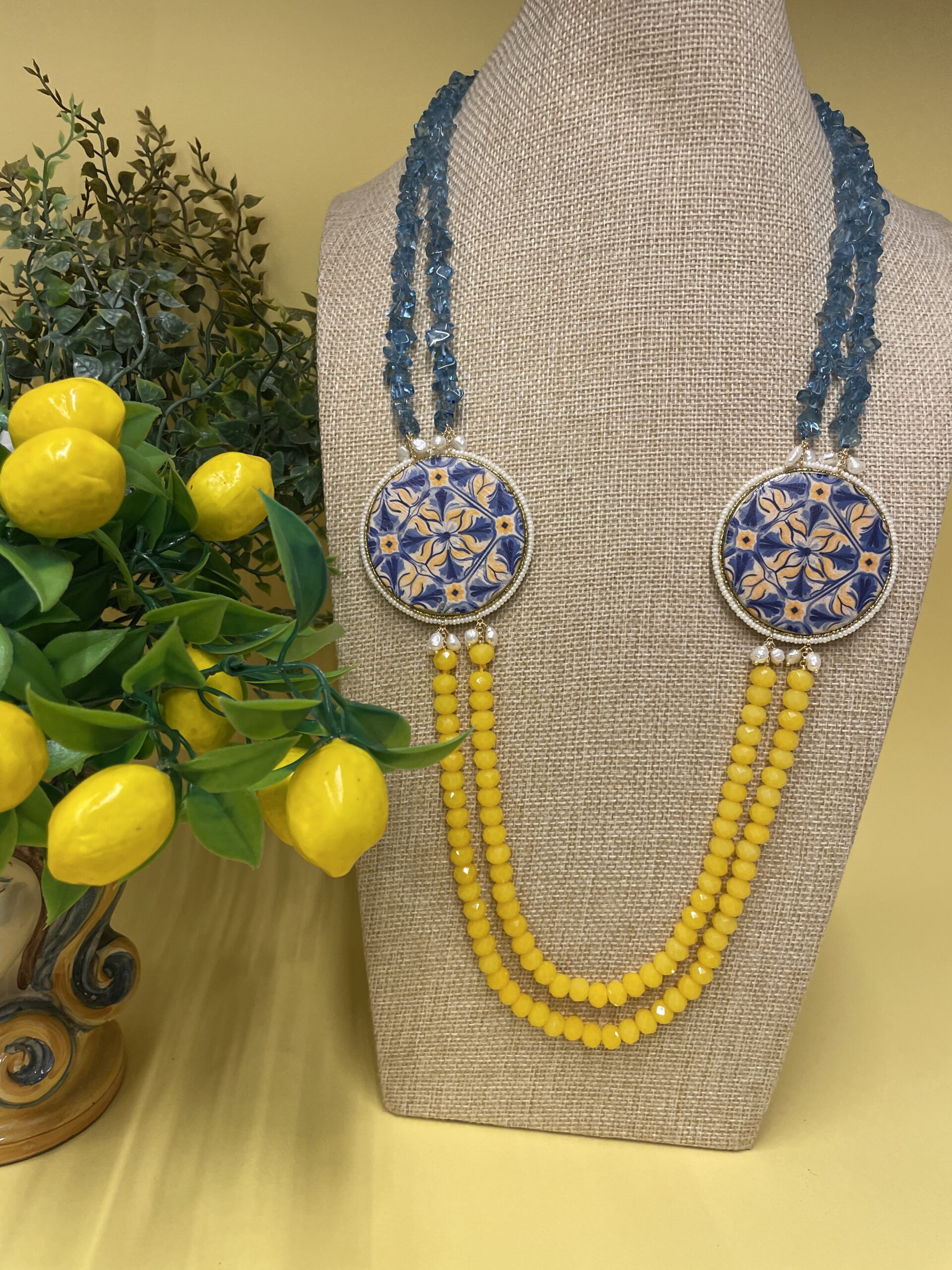 Collana artigianale con medaglioni double-face raffiguranti Limoni e fantasie geometriche, doppio colore giallo e acquamarina. Collane caratteristiche siciliane