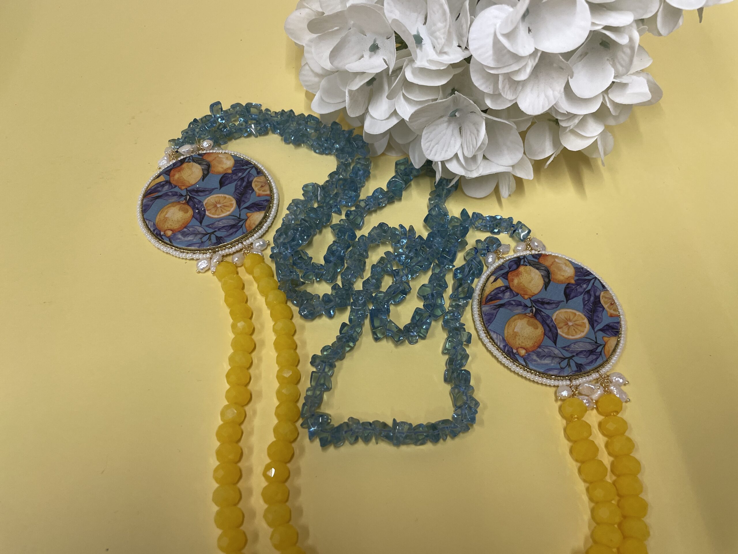 Collana artigianale con medaglioni double-face raffiguranti Limoni e fantasie geometriche, doppio colore giallo e acquamarina. Collane caratteristiche siciliane