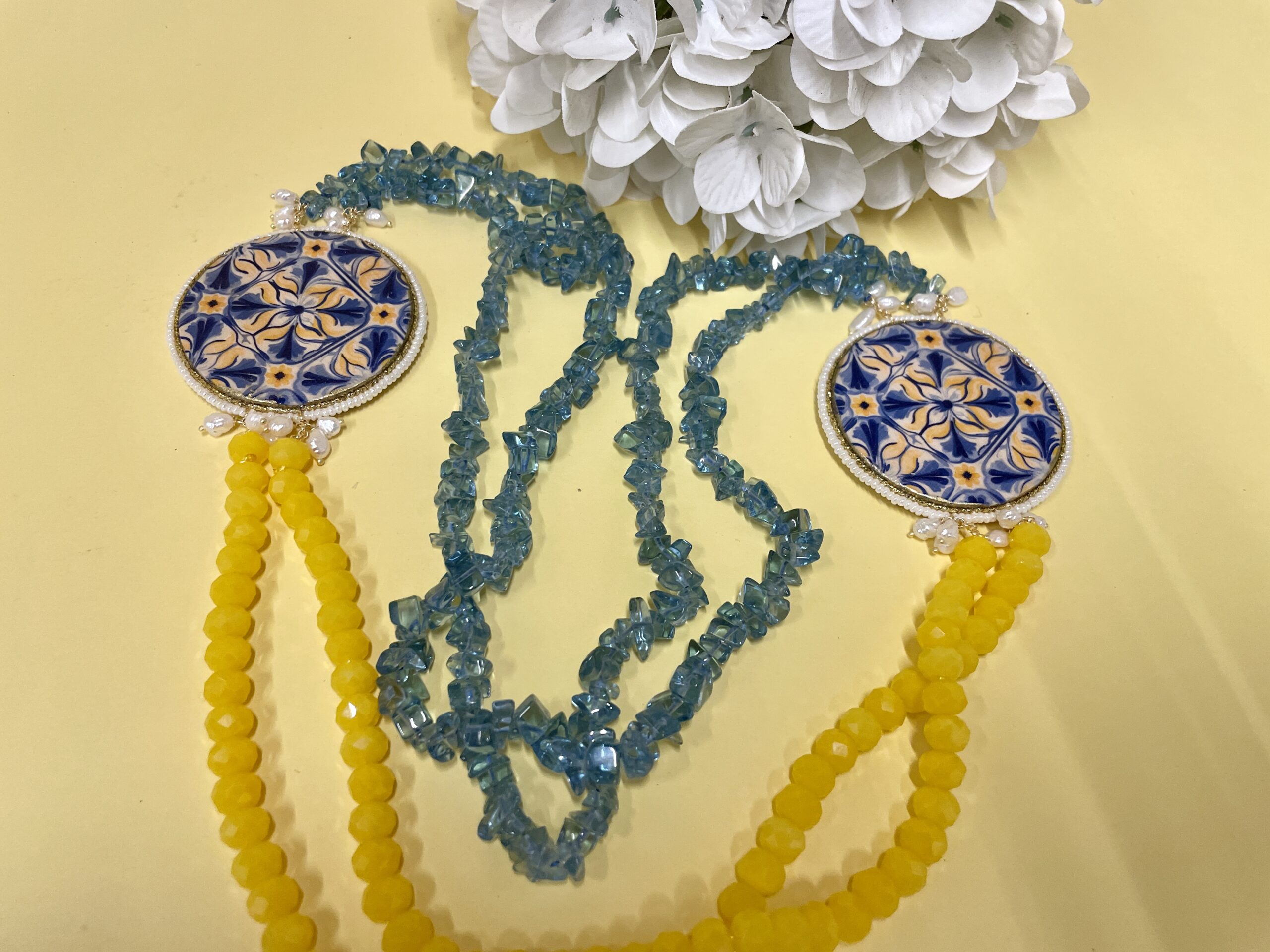 Collana artigianale con medaglioni double-face raffiguranti Limoni e fantasie geometriche, doppio colore giallo e acquamarina. Collane caratteristiche siciliane