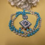 Collana siciliana artigianale con perle Maiorca bianche e turchesi e due mattonelle di ceramica di Caltagirone.